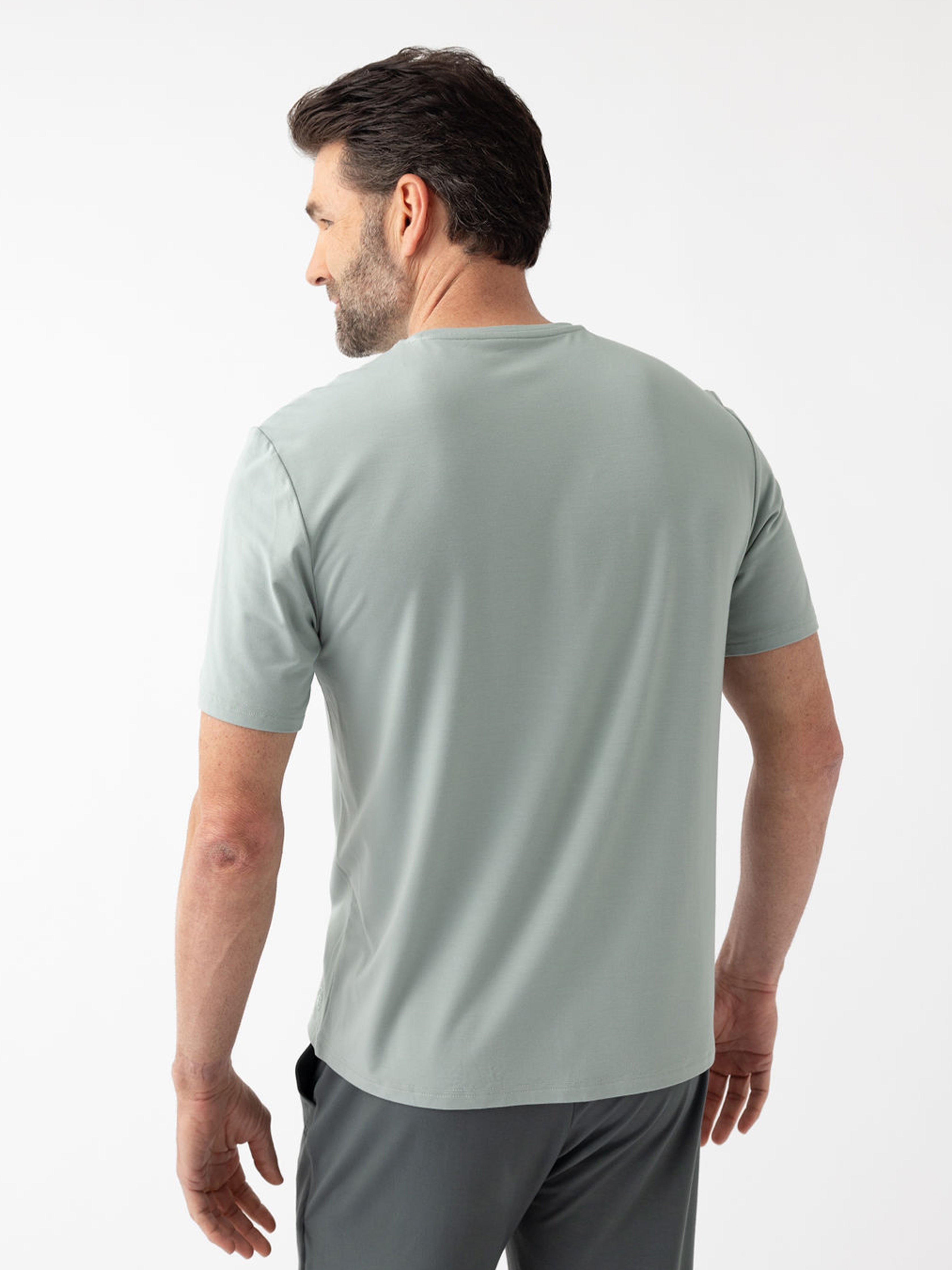 Back of man wearing haze pajama shirt with white background 
