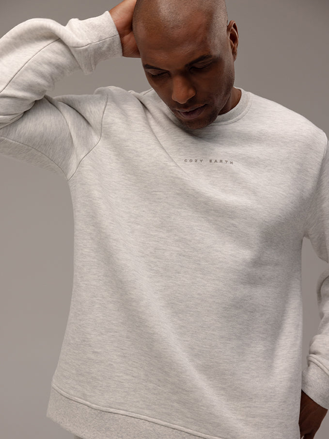 Close up of man wearing heather grey cityscape pullover with gray background 