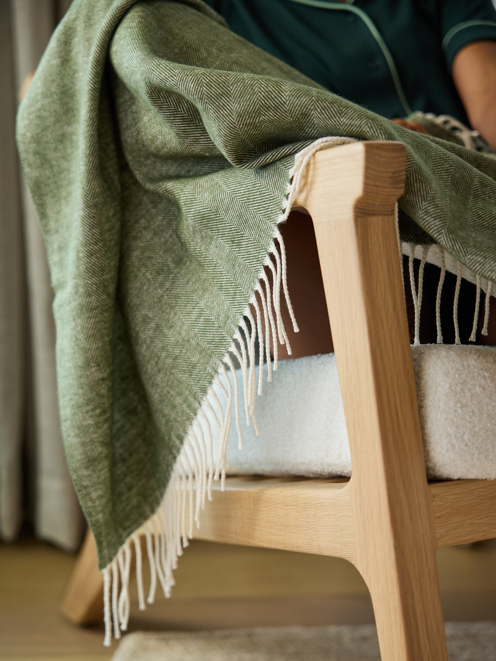 Close up of ivy herringbone tassel throw draped over chair 