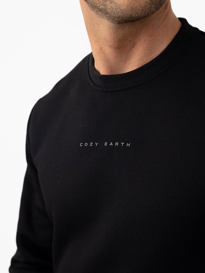 Close up of man wearing black cityscape pullover with white background 