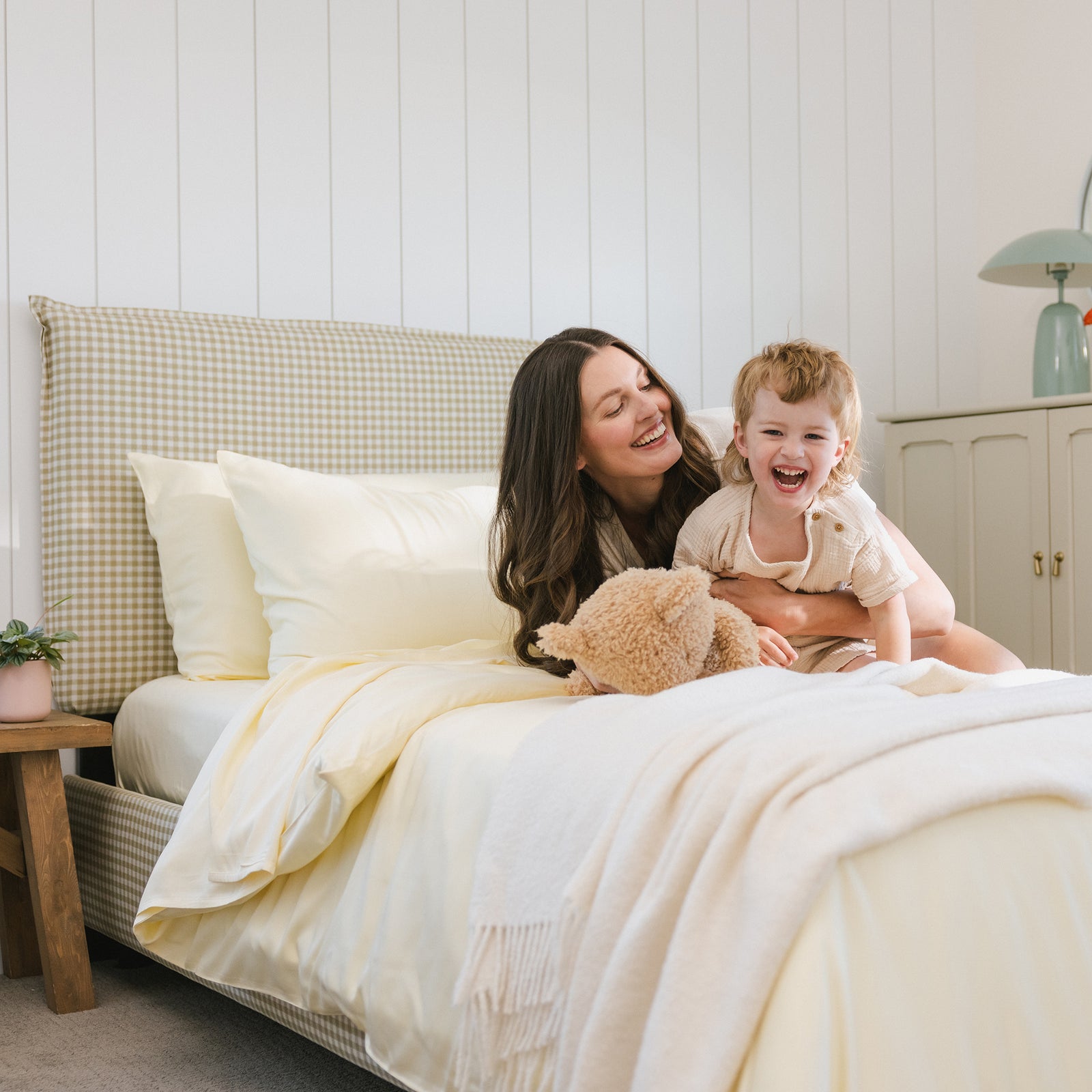 Women with boy smiling on bed with lemonade bedding 