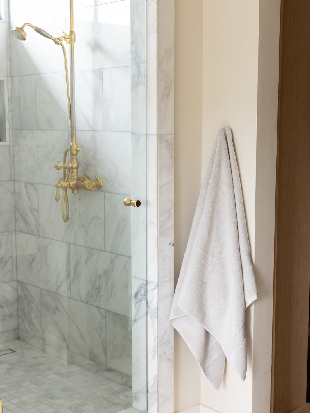 Light grey luxe bath sheet hanging next to shower 
