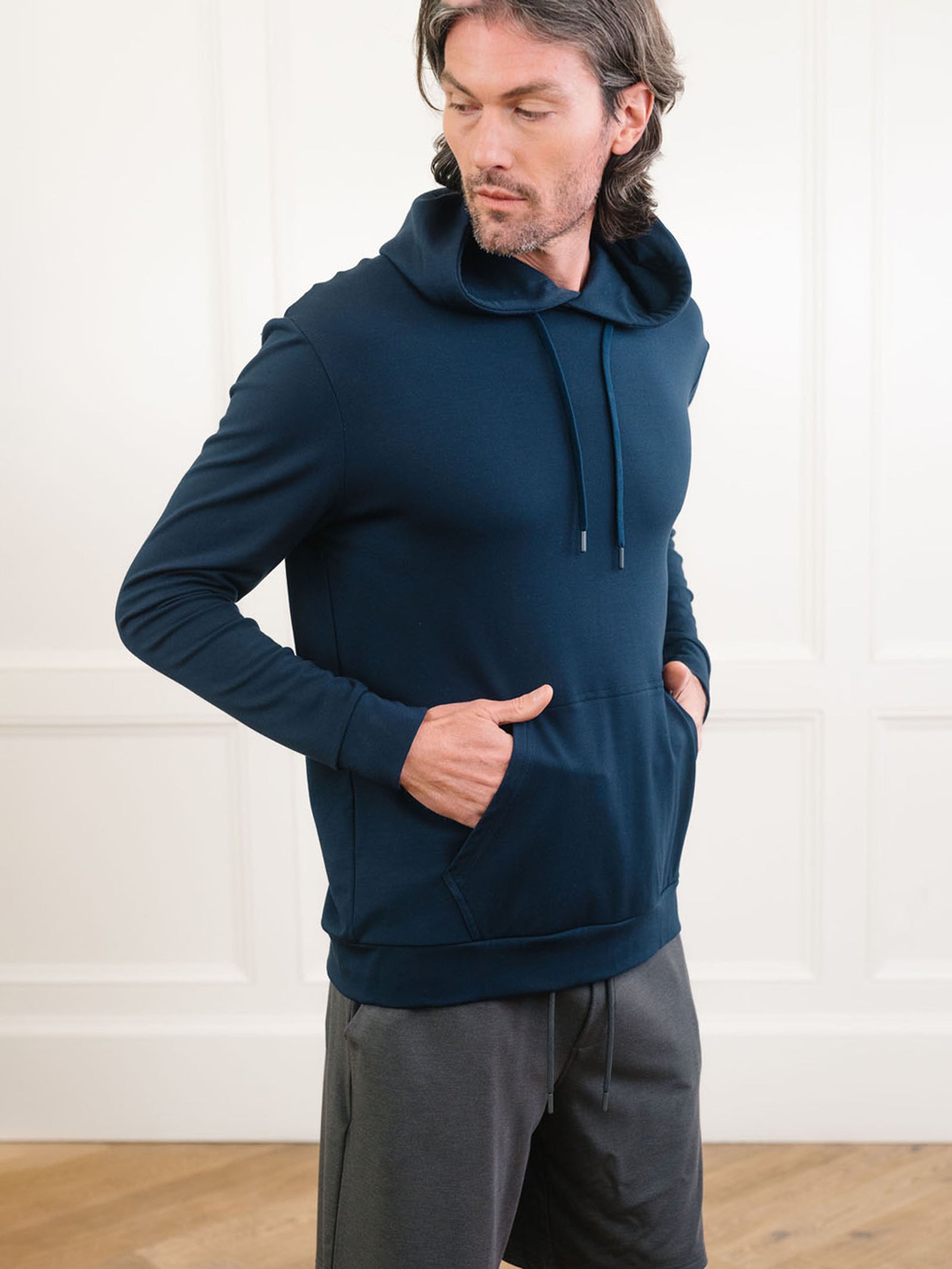 Navy Bamboo Hoodie worn by man standing in front of white background.