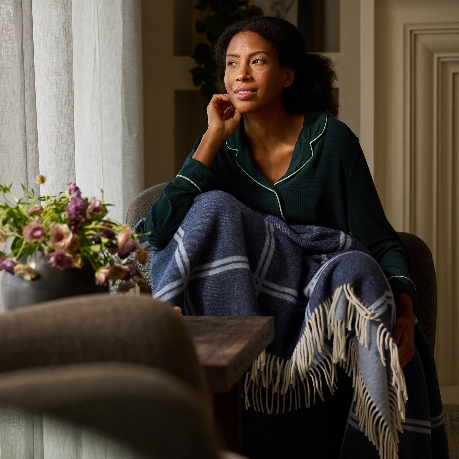 Woman sitting on recliner with navy cortina throw 