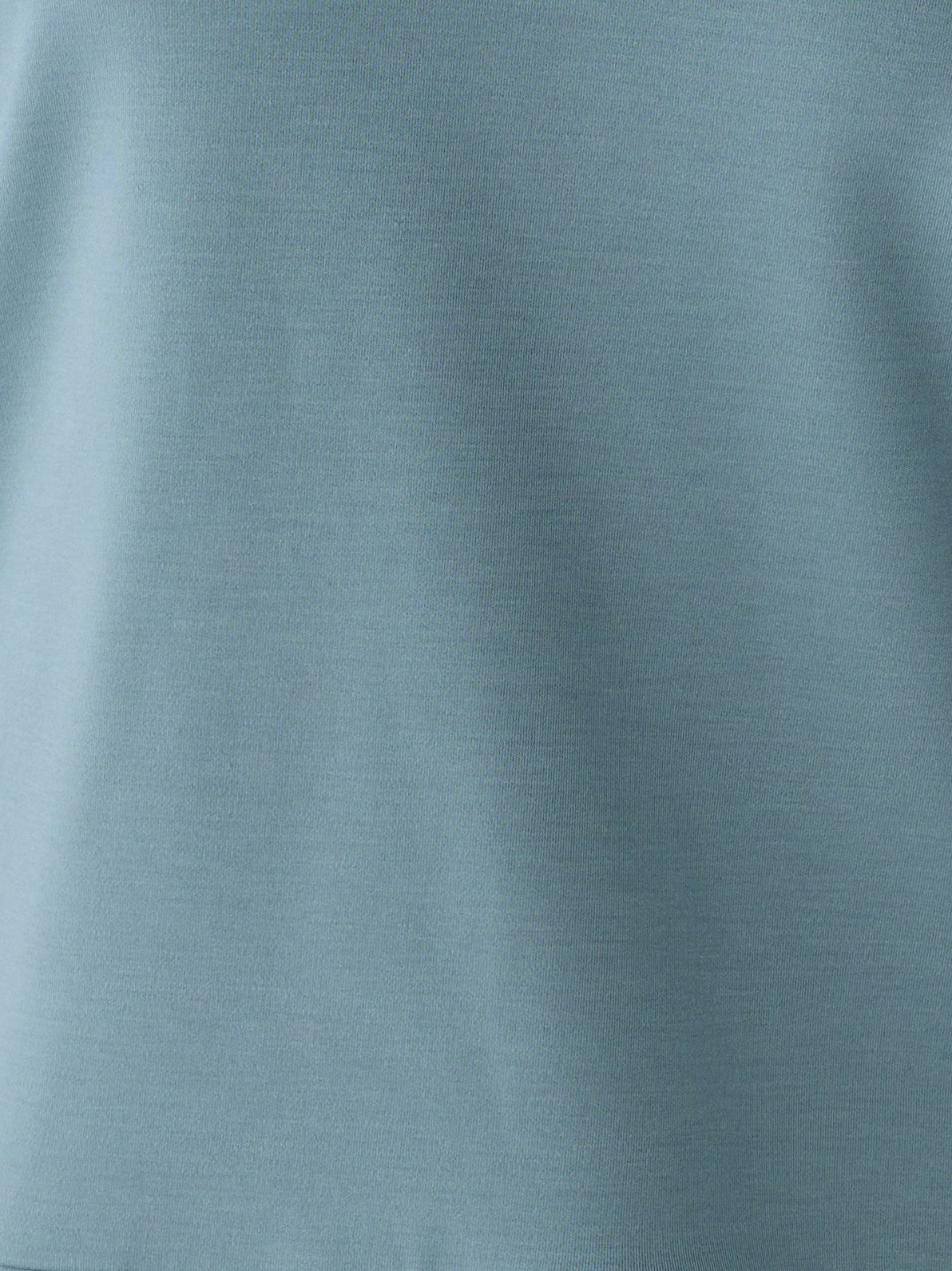 Close-up of the Women's Ultra-Soft Bamboo Pullover Crew by Cozy Earth in light blue. The fabric showcases a soft, smooth texture with an evenly colored surface and a fine, consistent weave that creates a uniform appearance. 