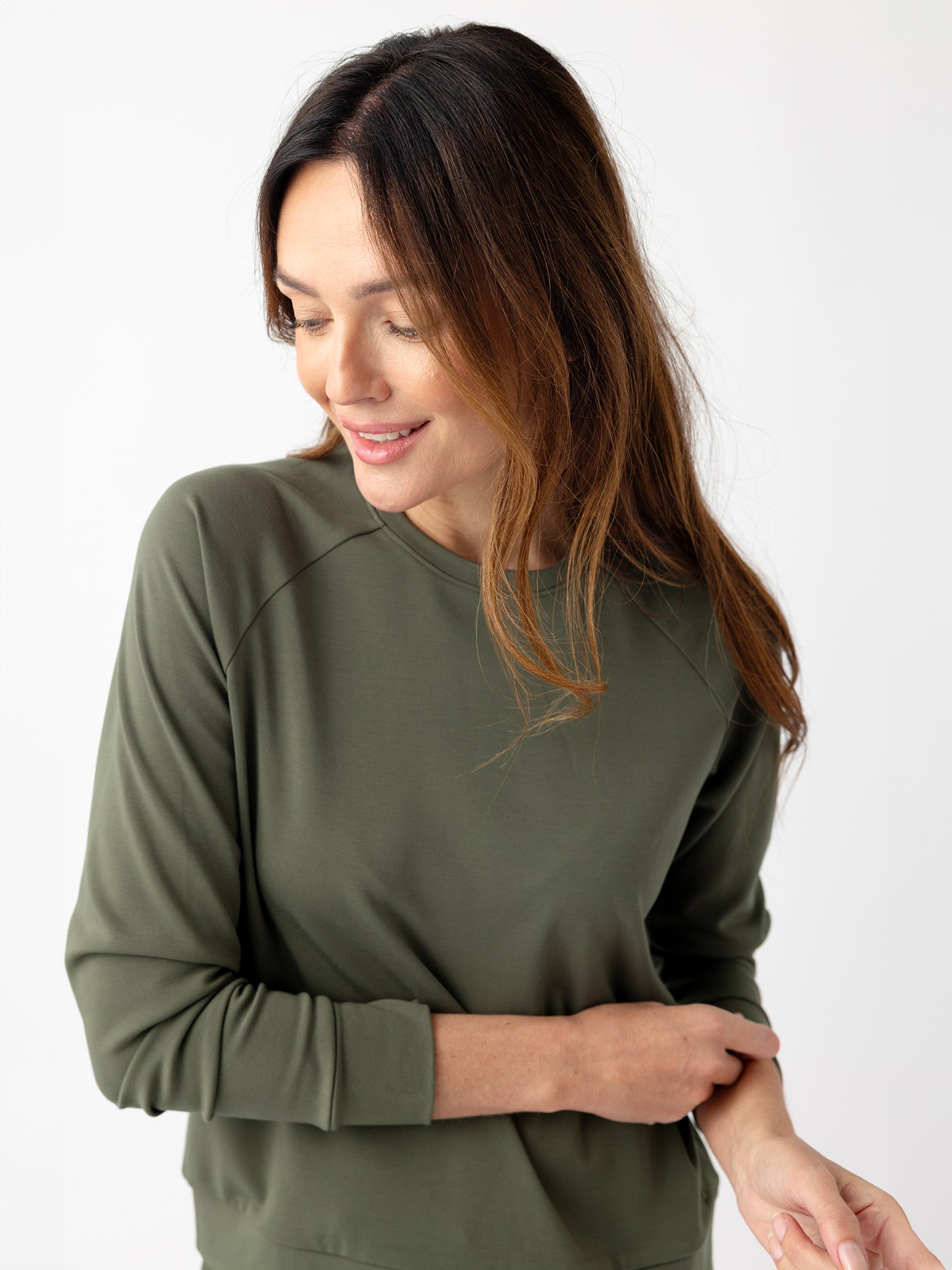 Woman in olive crewneck with white background 