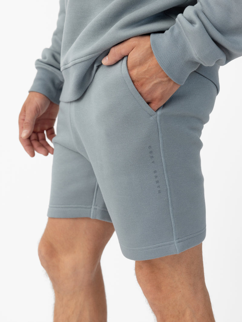Man wearing Smokey Blue CityScape Shorts with white background
