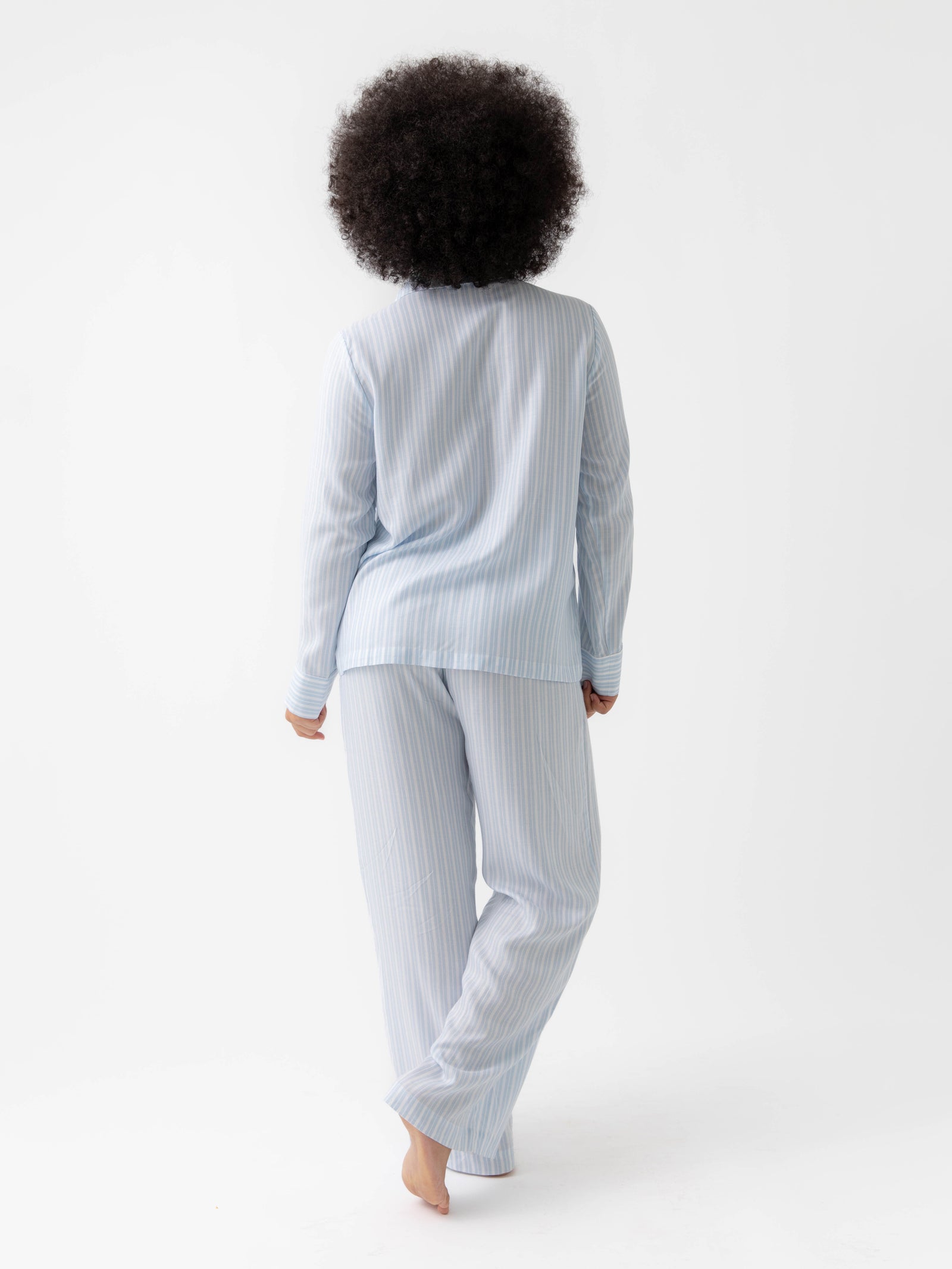 Woman wearing Spring Blue Stripe soft woven pajamas with white background 