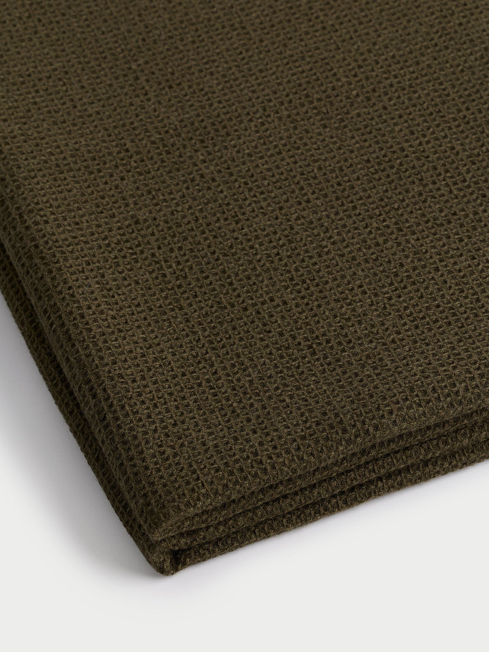 Corner of folded utility green alpaca throw 