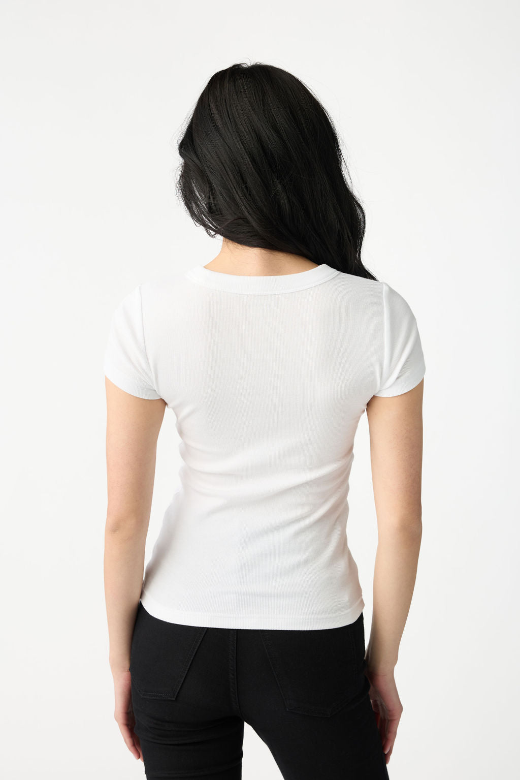 A dark haired woman wears Cozy Earth Women's Fine Ribbed Tee in White. She is turned away from the camera and pictured from the knees up. |Color:White