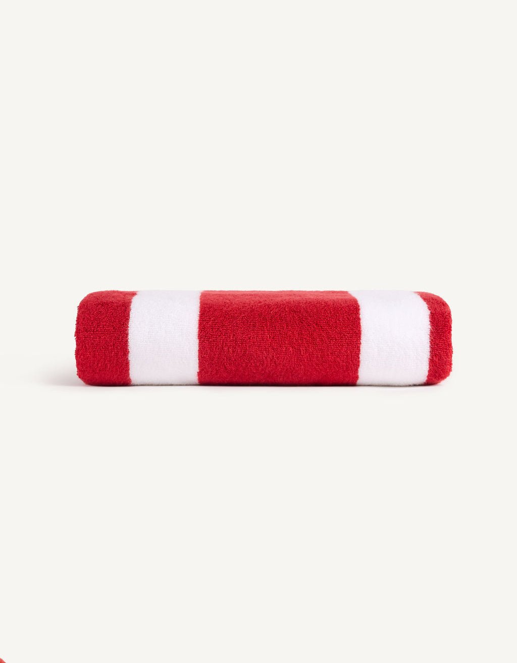 The Classic Stripe Resort Towel by Cozy Earth, featuring bold red and white stripes, is neatly folded against a plain light grey backdrop. |Color:Crimson