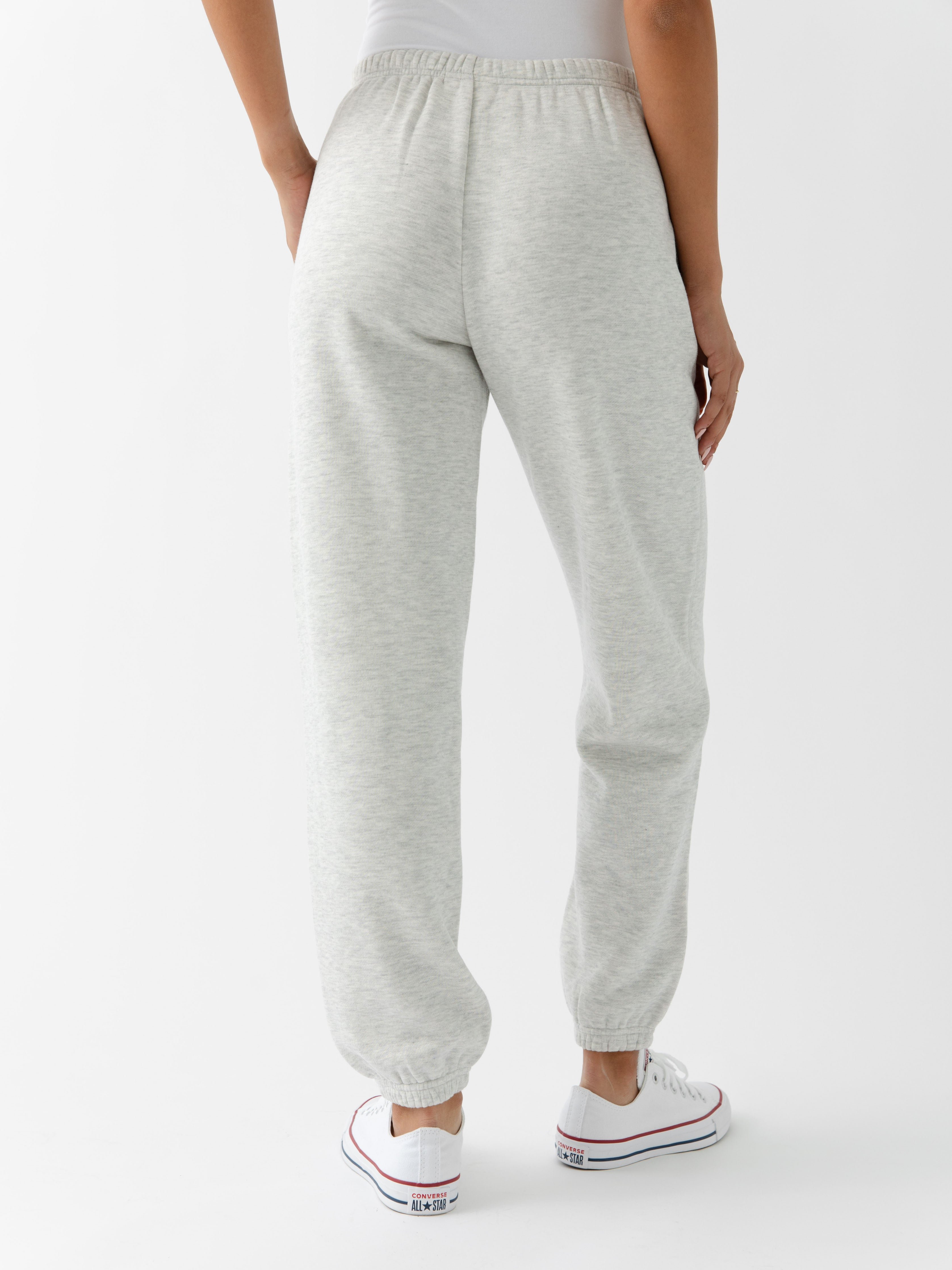 Heather Grey CityScape Joggers. The Joggers are being worn by a female model. The photo is taken from the waist down with the models hand in the pocket of the joggers. The back ground is white. 