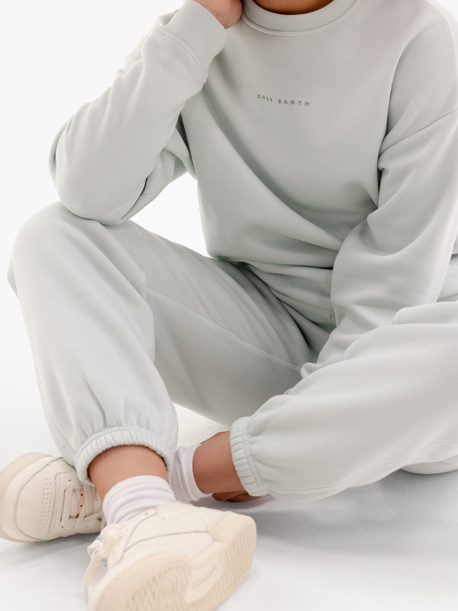 Arctic CityScape Pullover Crew. The Pullover is being worn by a female model. Accompanying city scape clothing is being worn to complete the look of the outfit. The photo was taken with a white background. 