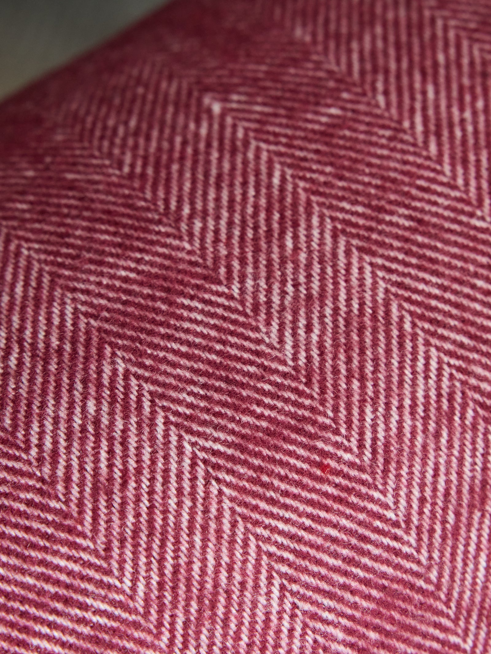 Close up of berry herringbone tassel throw 