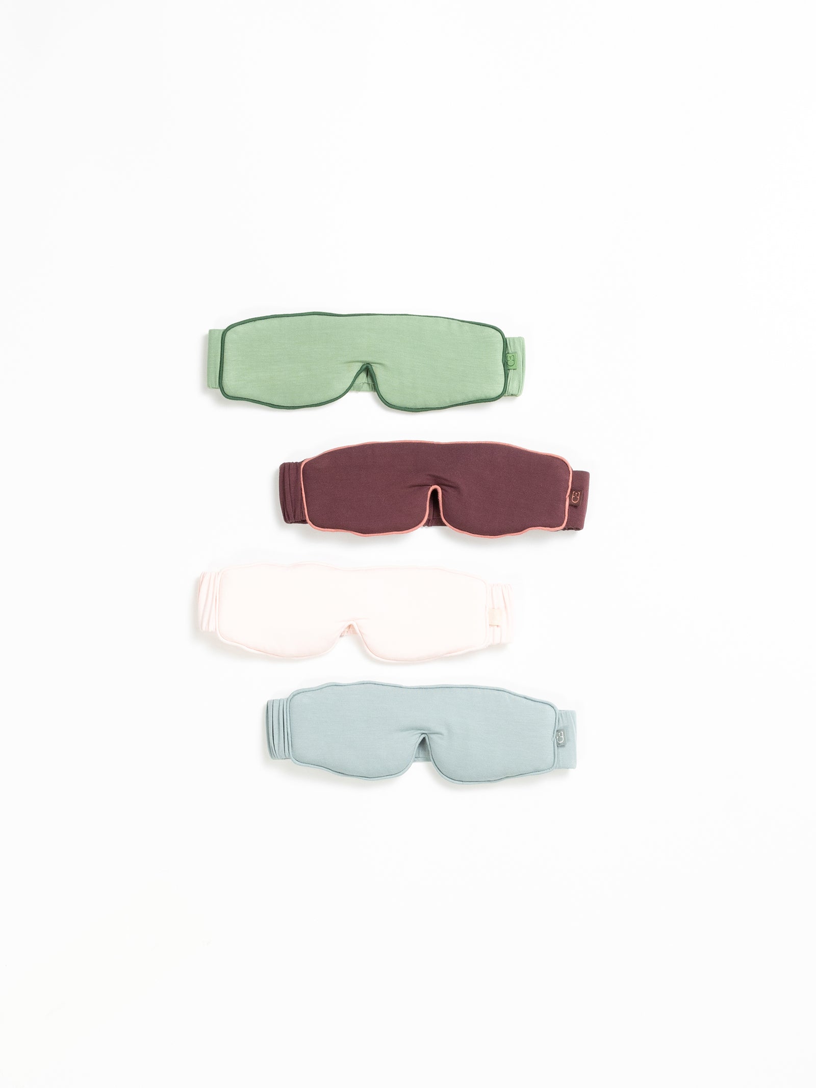 Flay lay of four different colors of sleep masks with white background 