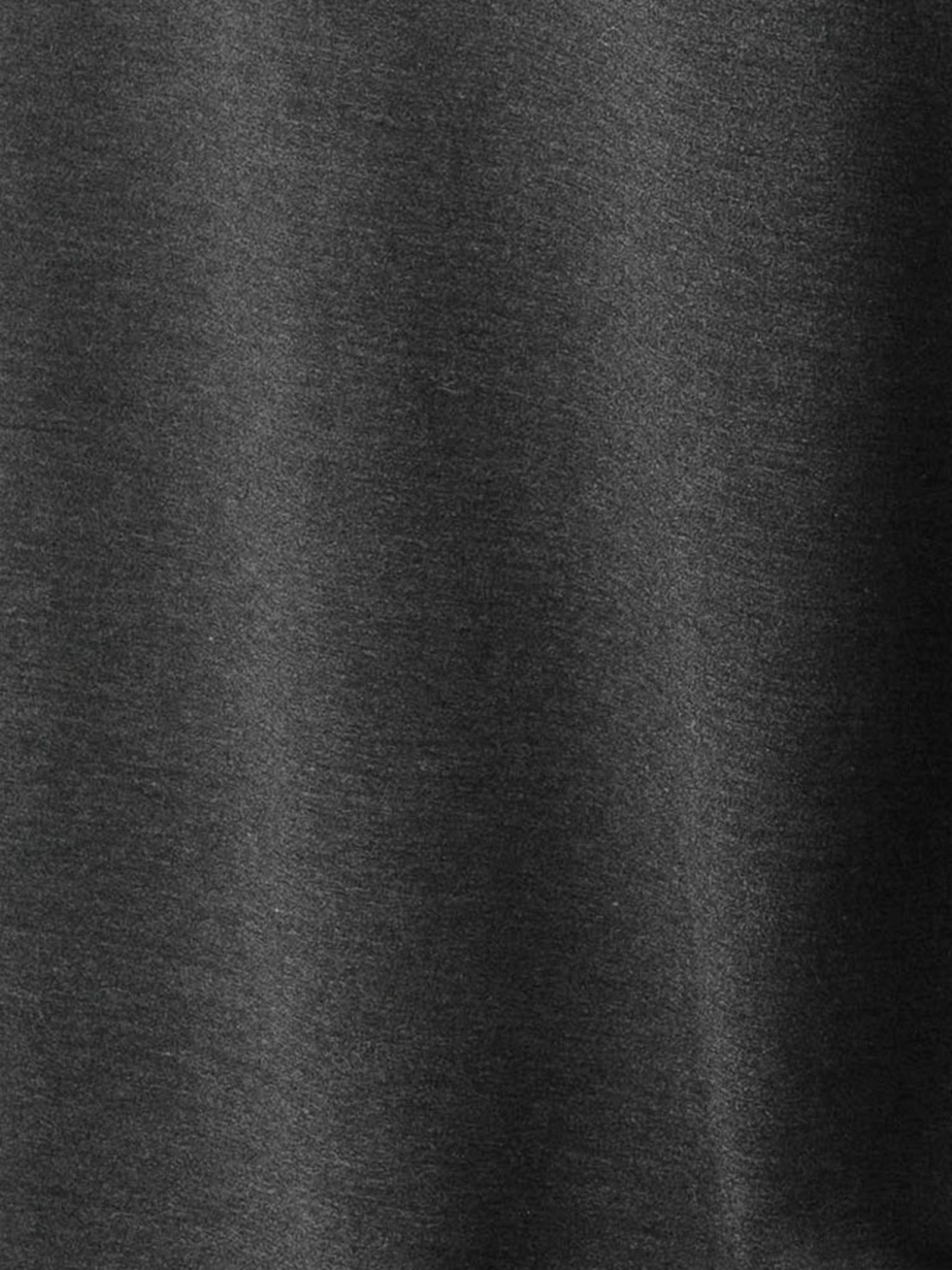 A close-up of the smooth, dark grey fabric from the Men's Stretch-Knit Long Sleeve Bamboo Pajama Jogger Set by Cozy Earth. The material exhibits a subtle, slightly shiny texture, appearing soft and flexible with slight variations in shading due to light reflections. 