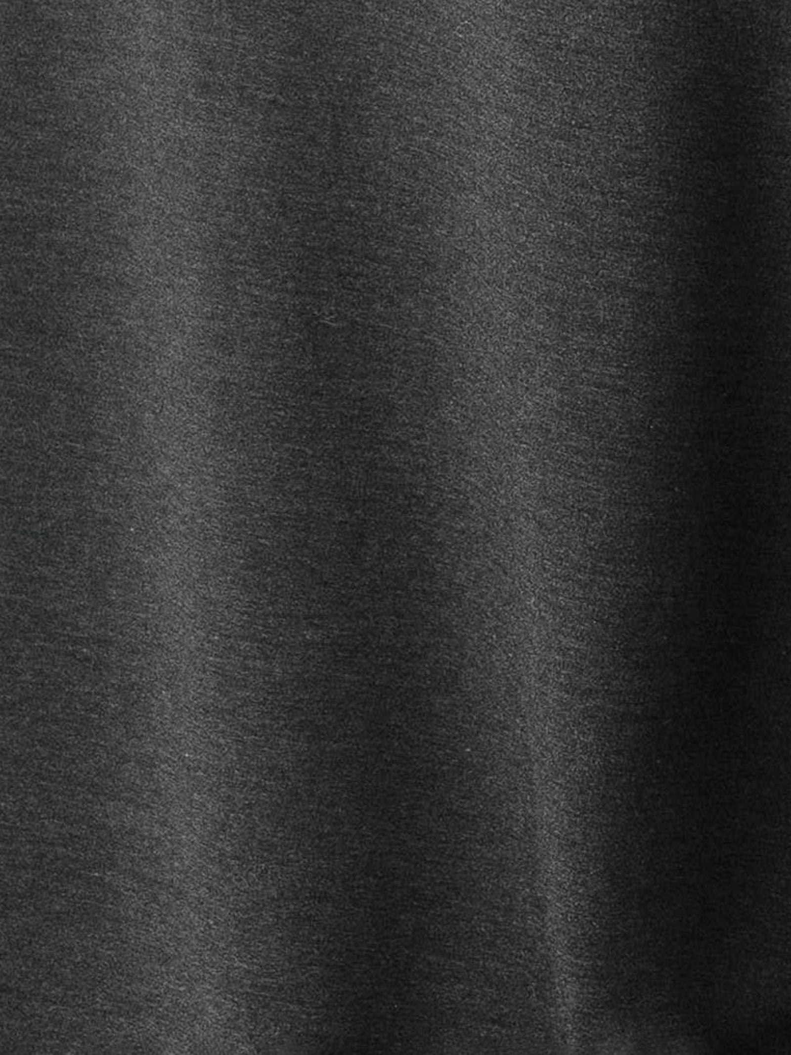 Close-up of the fabric from the Men's Stretch-Knit Short Sleeve Bamboo Pajama Set by Cozy Earth, showcasing its smooth, dark gray appearance with a subtle sheen and visible texture. The material drapes effortlessly, creating gentle folds and soft shadows.