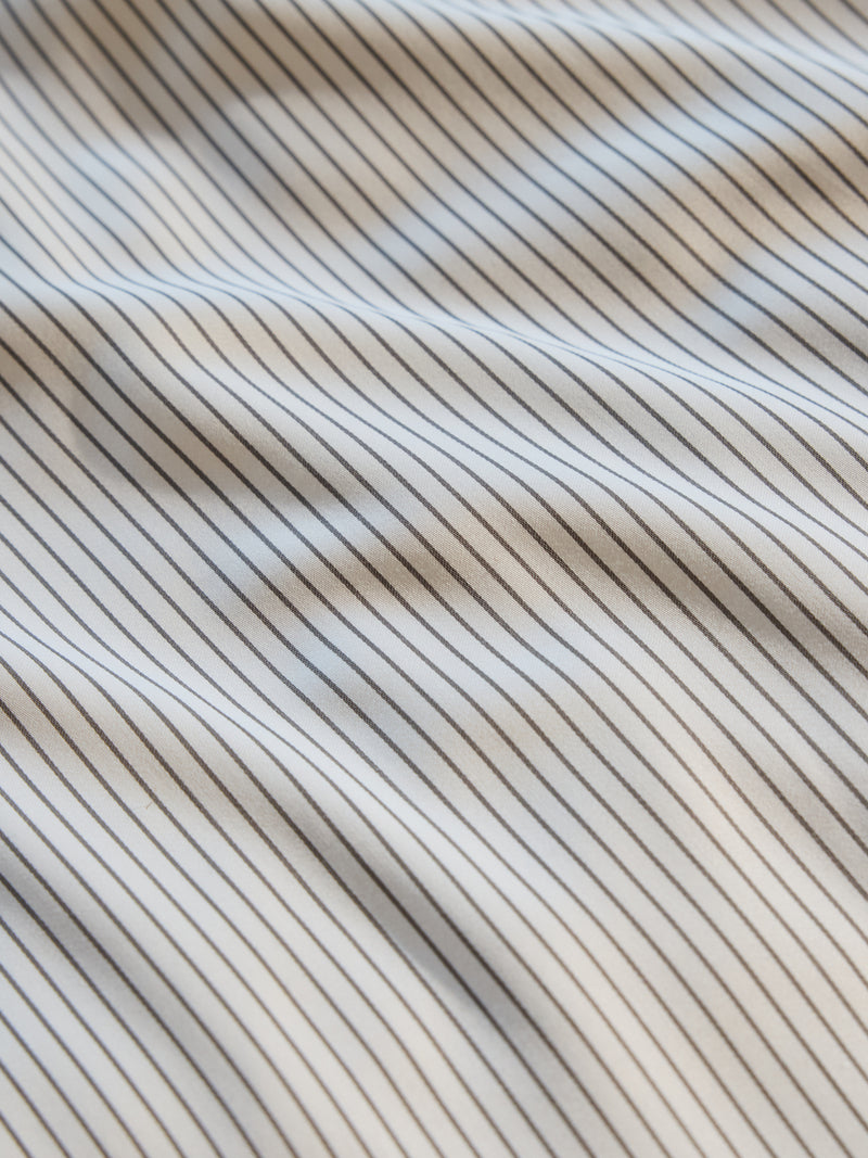 Close-up of the Bamboo Duvet Cover by Cozy Earth, showcasing a textured design with thin, parallel black and white stripes. The duvet cover surface appears to have gentle waves, creating subtle shadows and highlights.