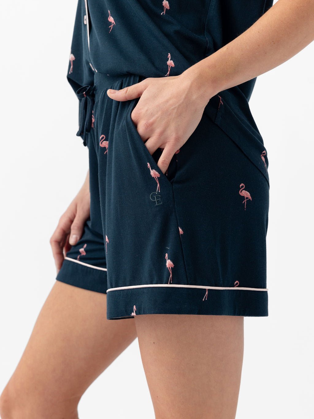 Woman wearing flamingo print pajama shorts with white background 