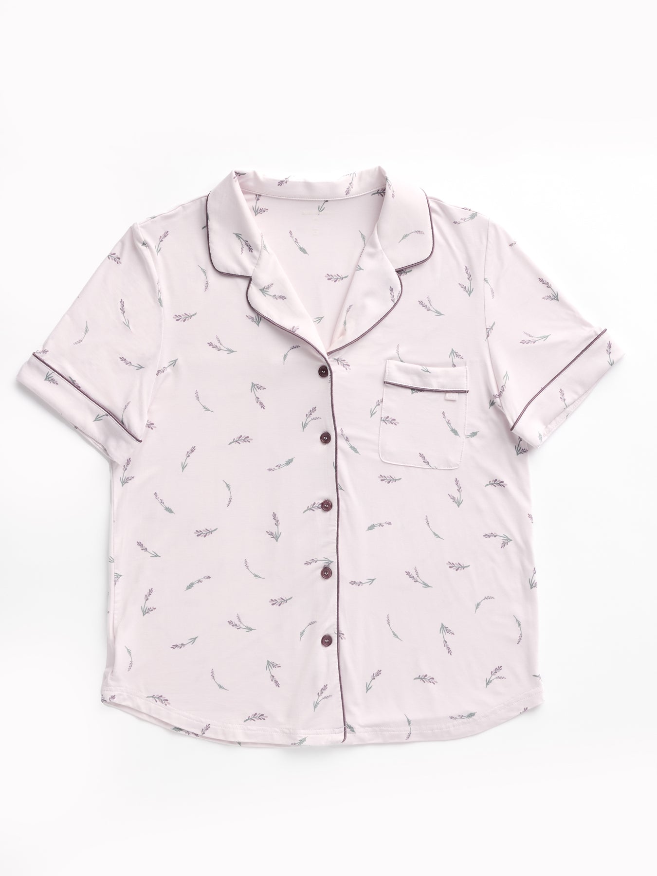 The Women's Bamboo Stretch-Knit Short Sleeve Pajama Top by HIDE is light lavender with a small leaf pattern, dark buttons, notched collar, and a breast pocket accented with dark piping. It's laid flat on a white background. 