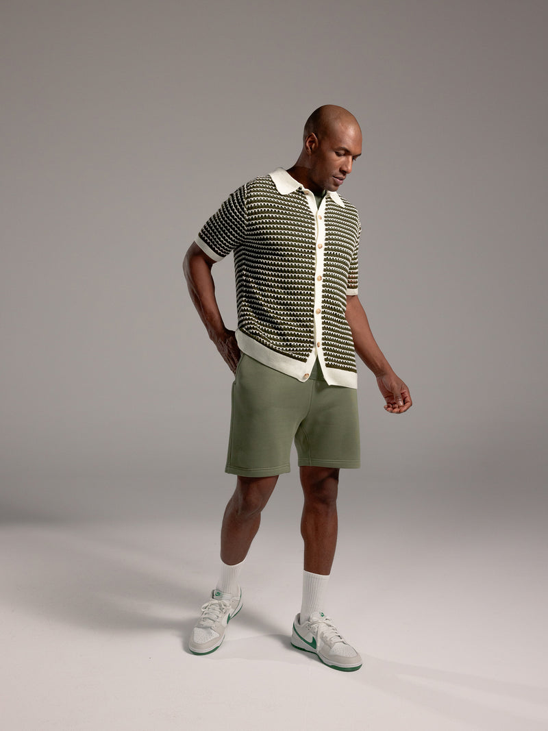 Man wearing Juniper CityScape Shorts with grey background