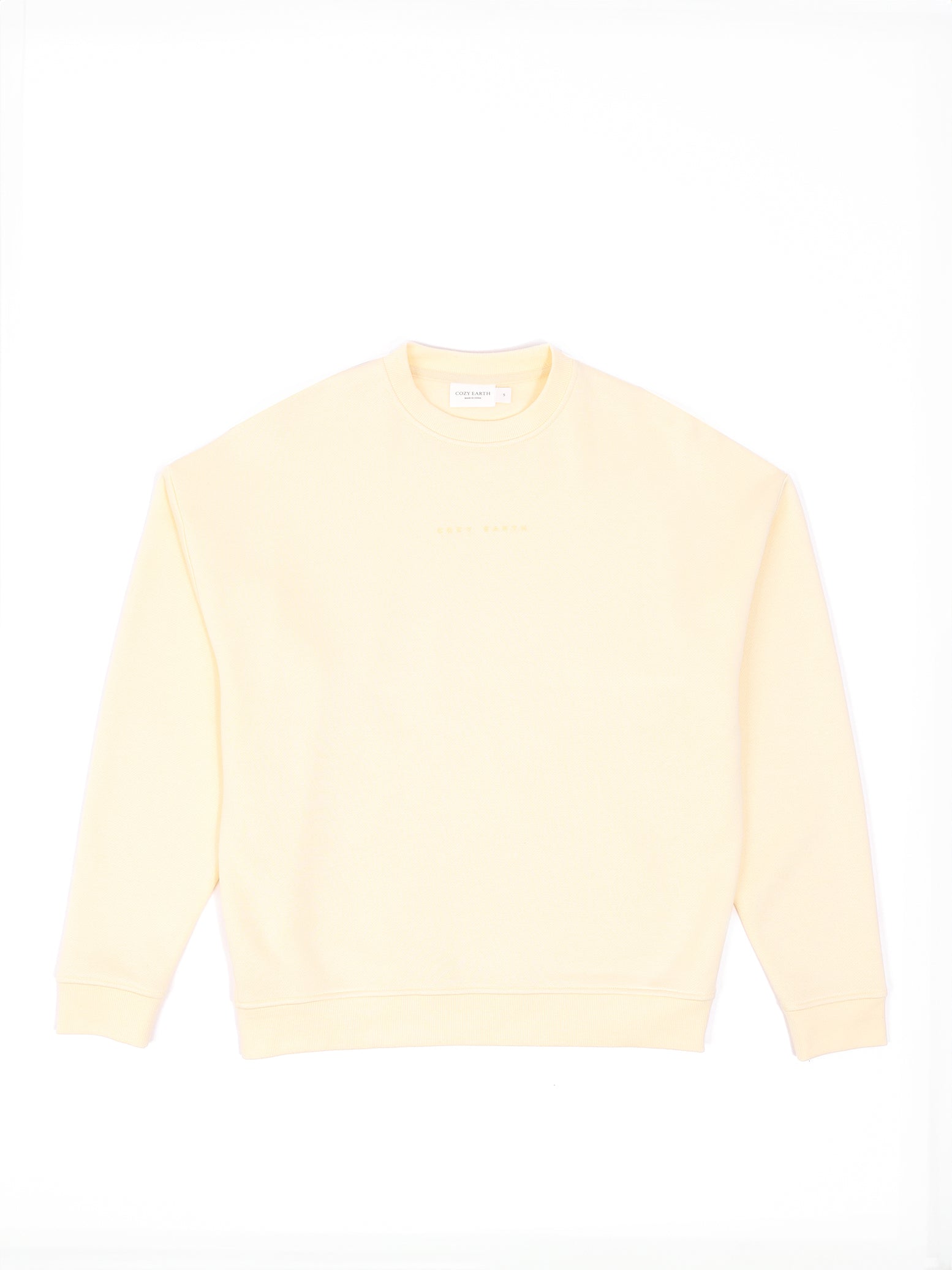 The Women's CityScape Crewneck by Cozy Earth is a light yellow sweatshirt with long sleeves, pictured flat against a white background with a small tag visible at the neckline. 