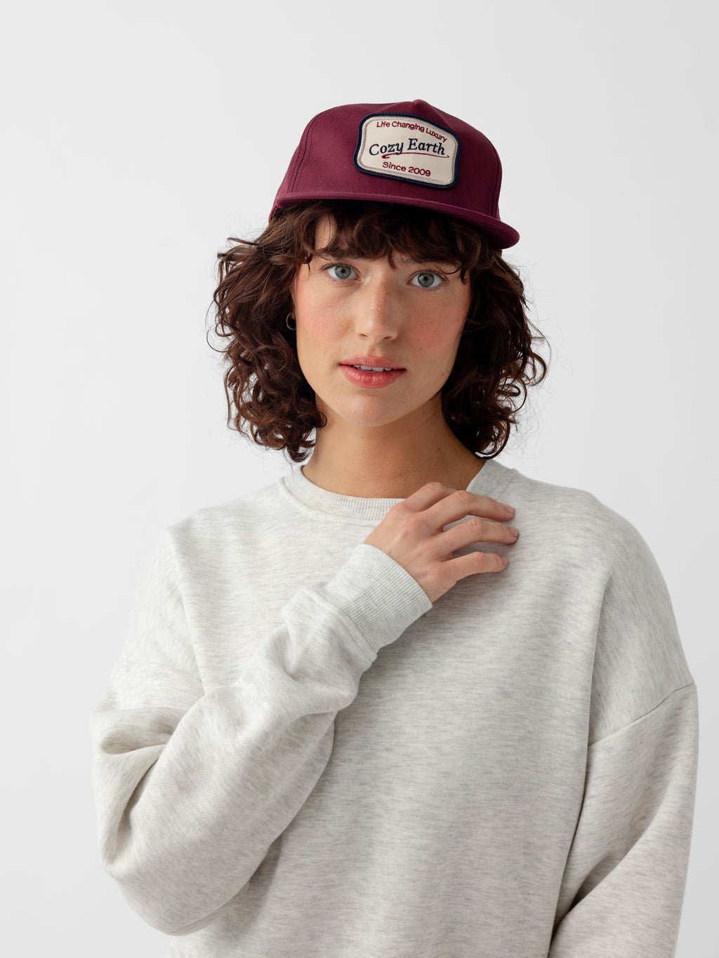 Woman looking at camera wearing maroon heritage snapback 