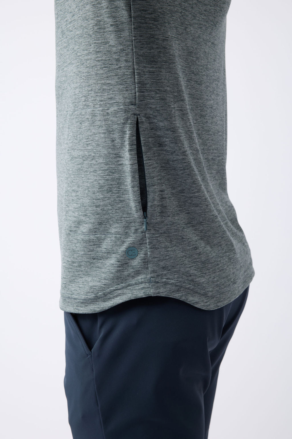 Close-up of a person wearing the Cozy Earth Men's Lightweight Performance Hoodie and dark blue pants, showcasing the textured design from mid-torso to mid-thigh against a plain background. 