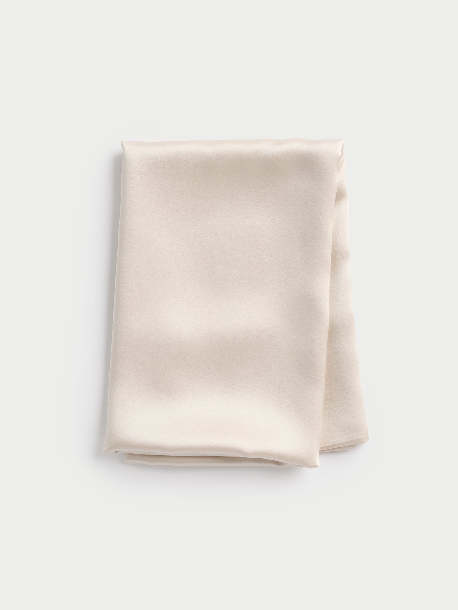 Folded Cozy Earth silk pillowcase against a light gray background. 