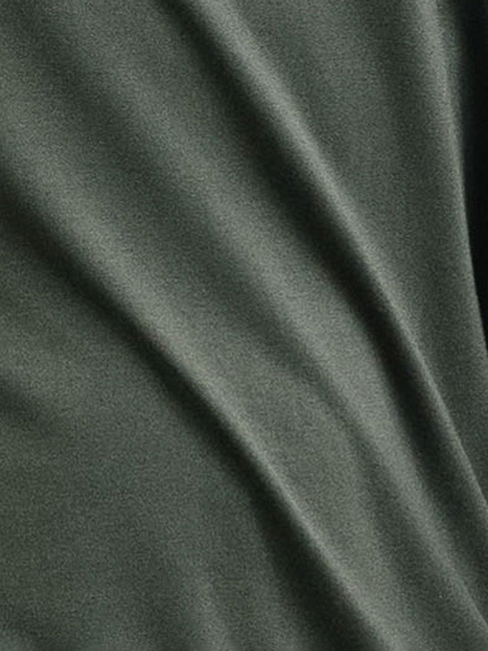 A close-up view of the Men's Stretch-Knit Long Sleeve Bamboo Pajama Jogger Set in dark green from Cozy Earth, showcasing its soft folds and smooth texture. 