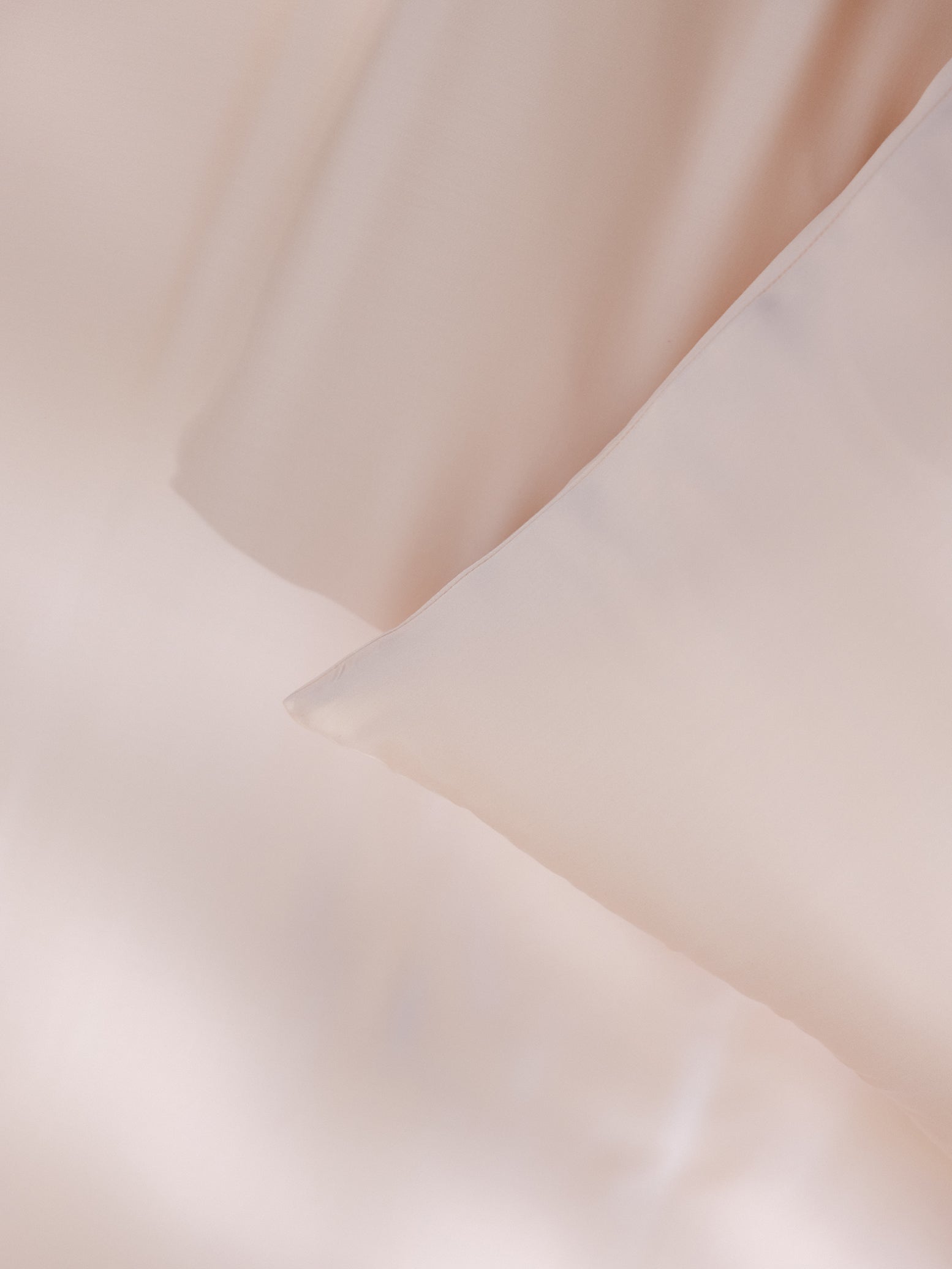 Peony Pillowcases on bed. Photo taken close up to show the texture of the pillowcases standard/king. 
