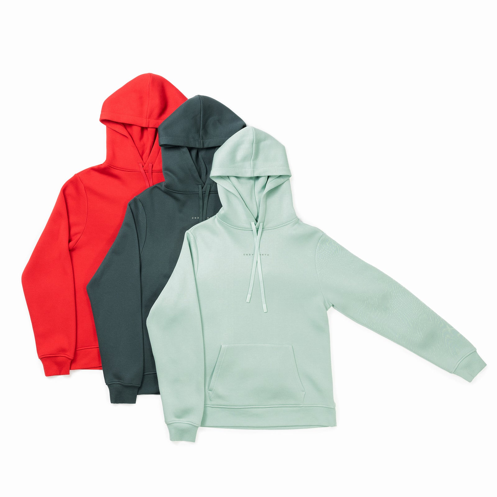 Three **Men's CityScape Hoodies** by **Cozy Earth** are showcased in a staggered arrangement. From left to right, they come in red, dark green, and light mint green colors. Each hoodie features a front pocket and a drawstring hood, with the mint green hoodie positioned in the foreground. 