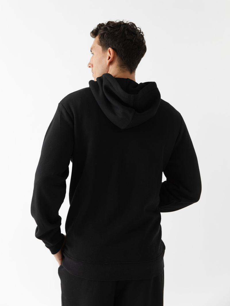 Back of man wearing black cityscape hoodie with white background