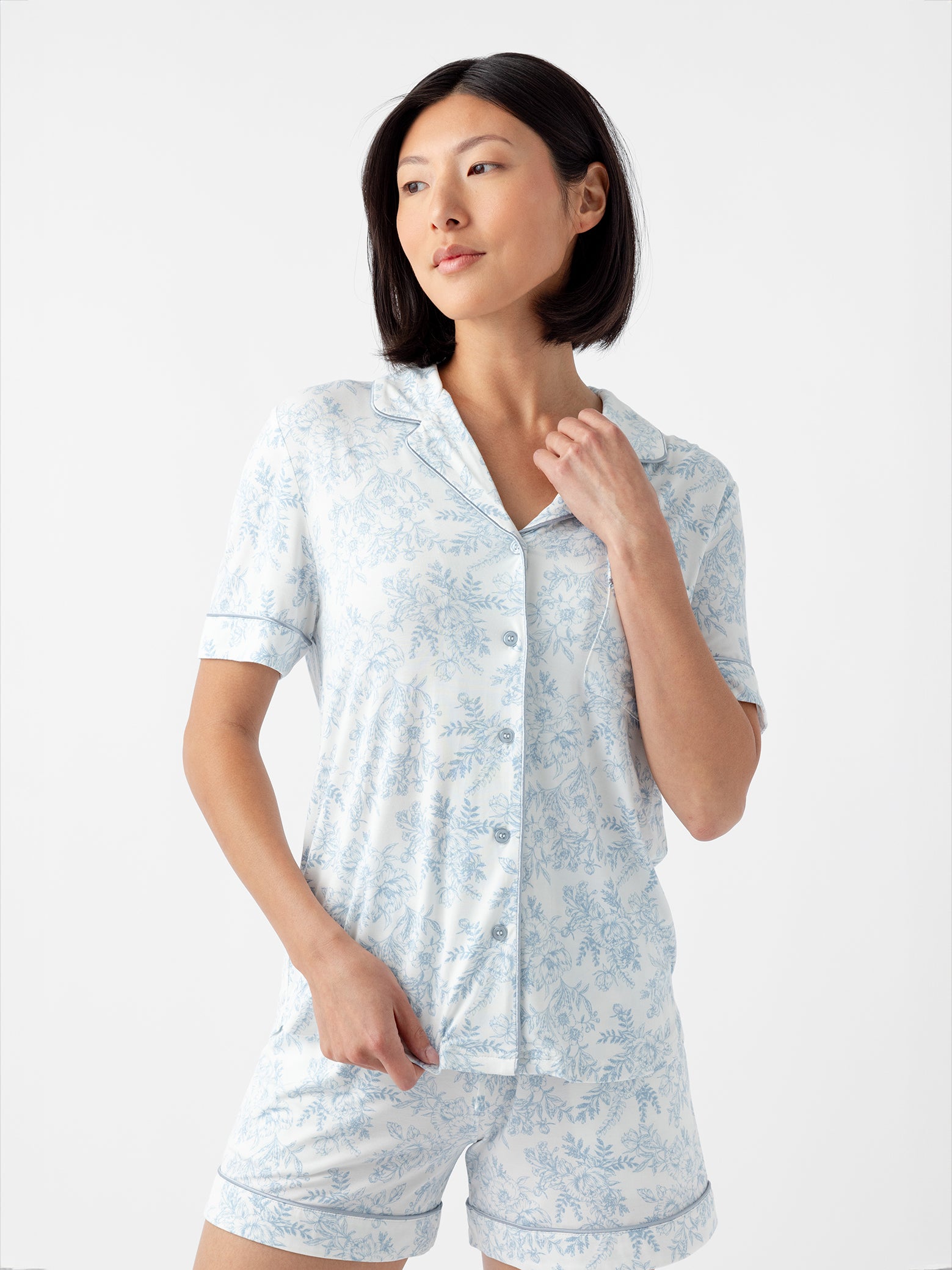 Woman in short sleeve blue toile pajama top with white background 