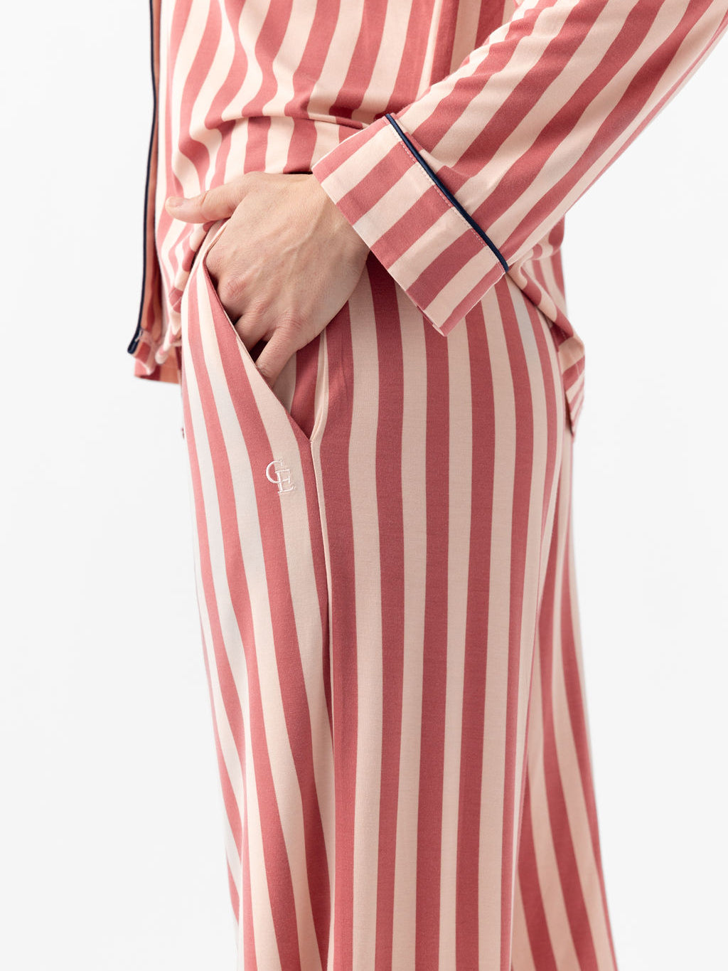 Close up of woman wearing blush stripe pajama pants with white background 