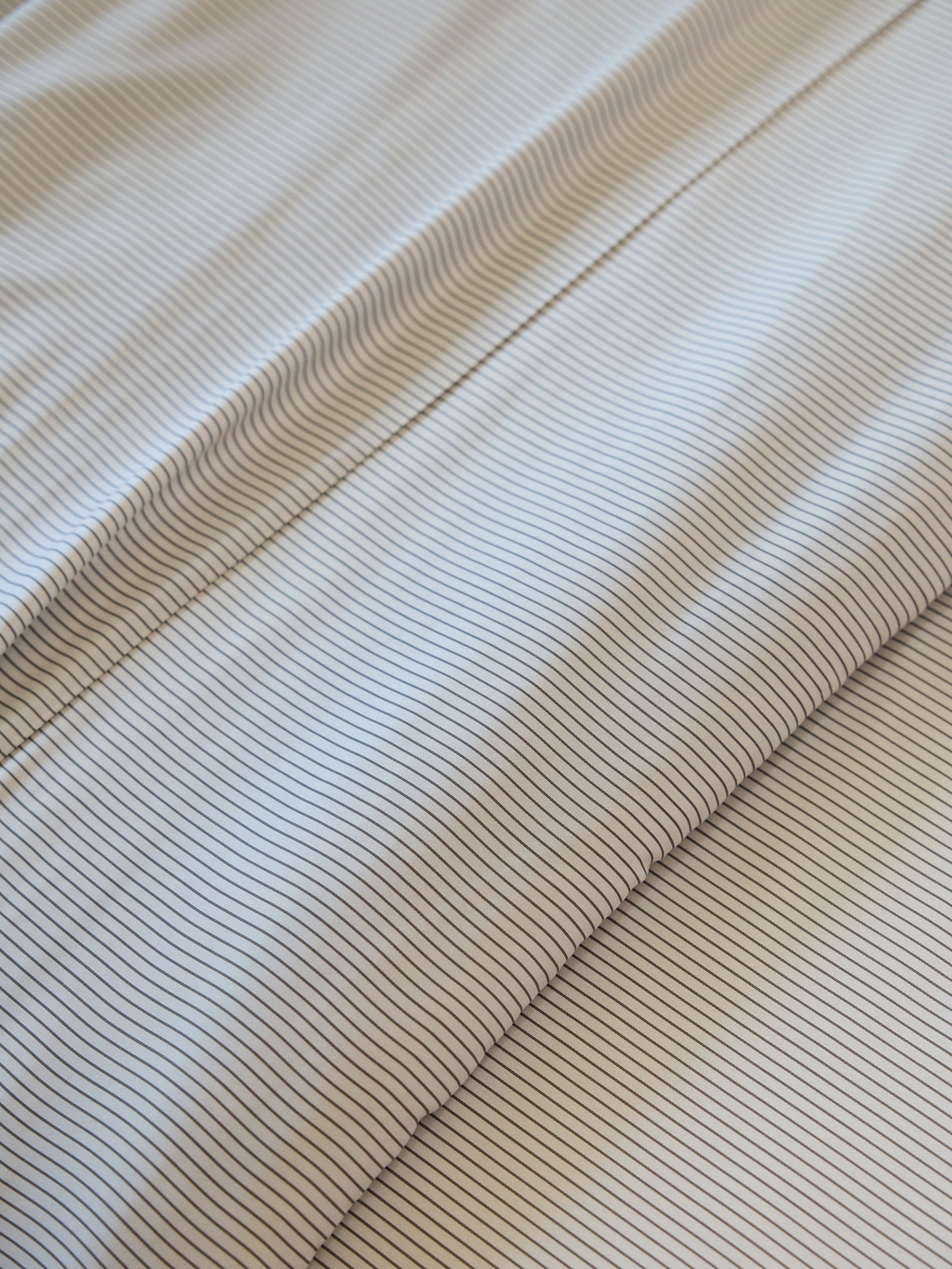 Cozy Earth's Bamboo Duvet Cover features a close-up design of thin, parallel lines that form a striped pattern. These evenly spaced lines create a textured and uniform appearance. 