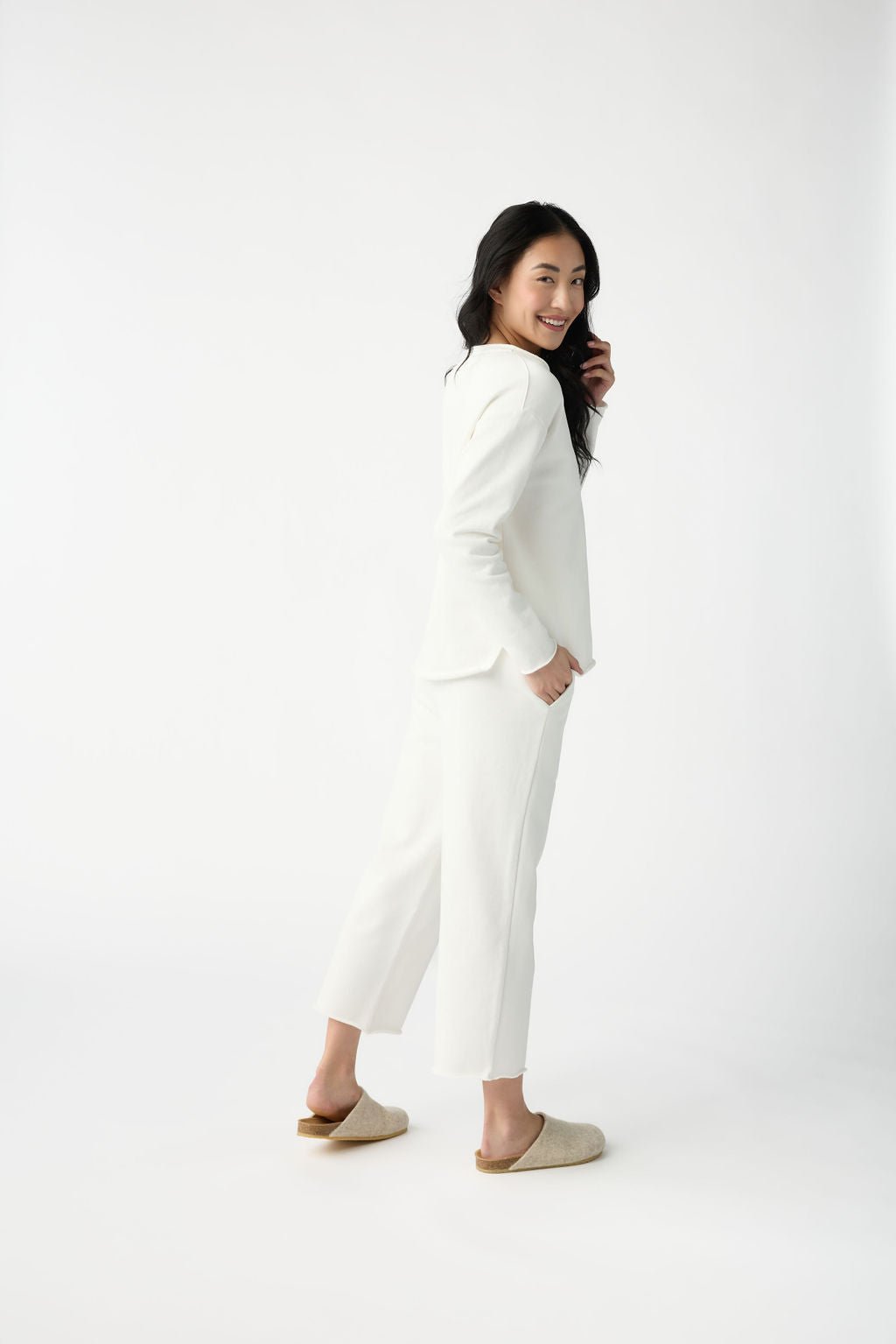 A woman with dark hair wears Cozy Earth Women's Chelsea Cropped Pant in Bone in front of a white background. |Color:Bone