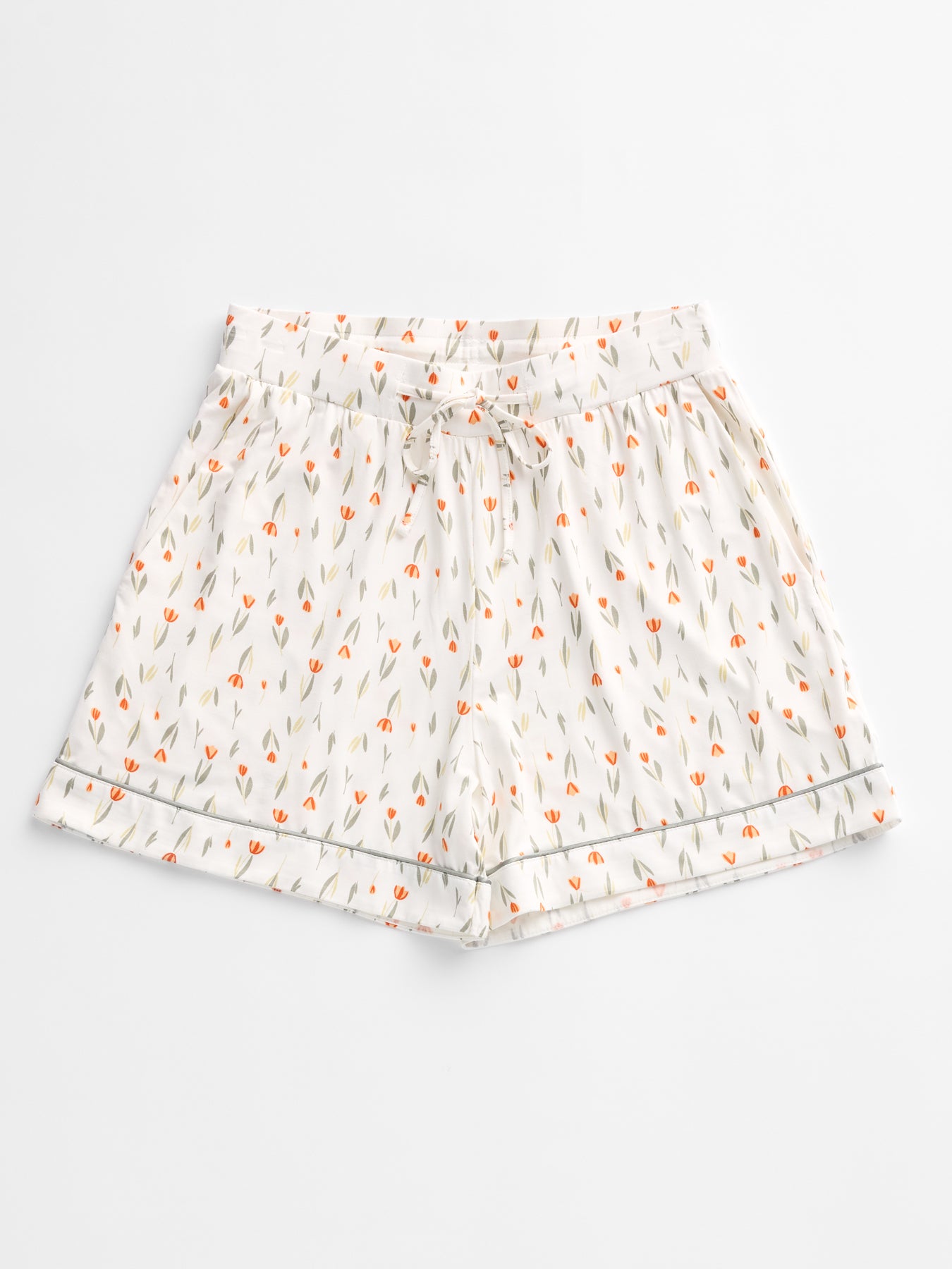 The Women's Bamboo Stretch-Knit Pajama Short by HIDE, featuring a small floral pattern with orange flowers and green leaves, elastic waistband, drawstring, and hem with a subtle decorative border, is laid flat on a plain white background. 