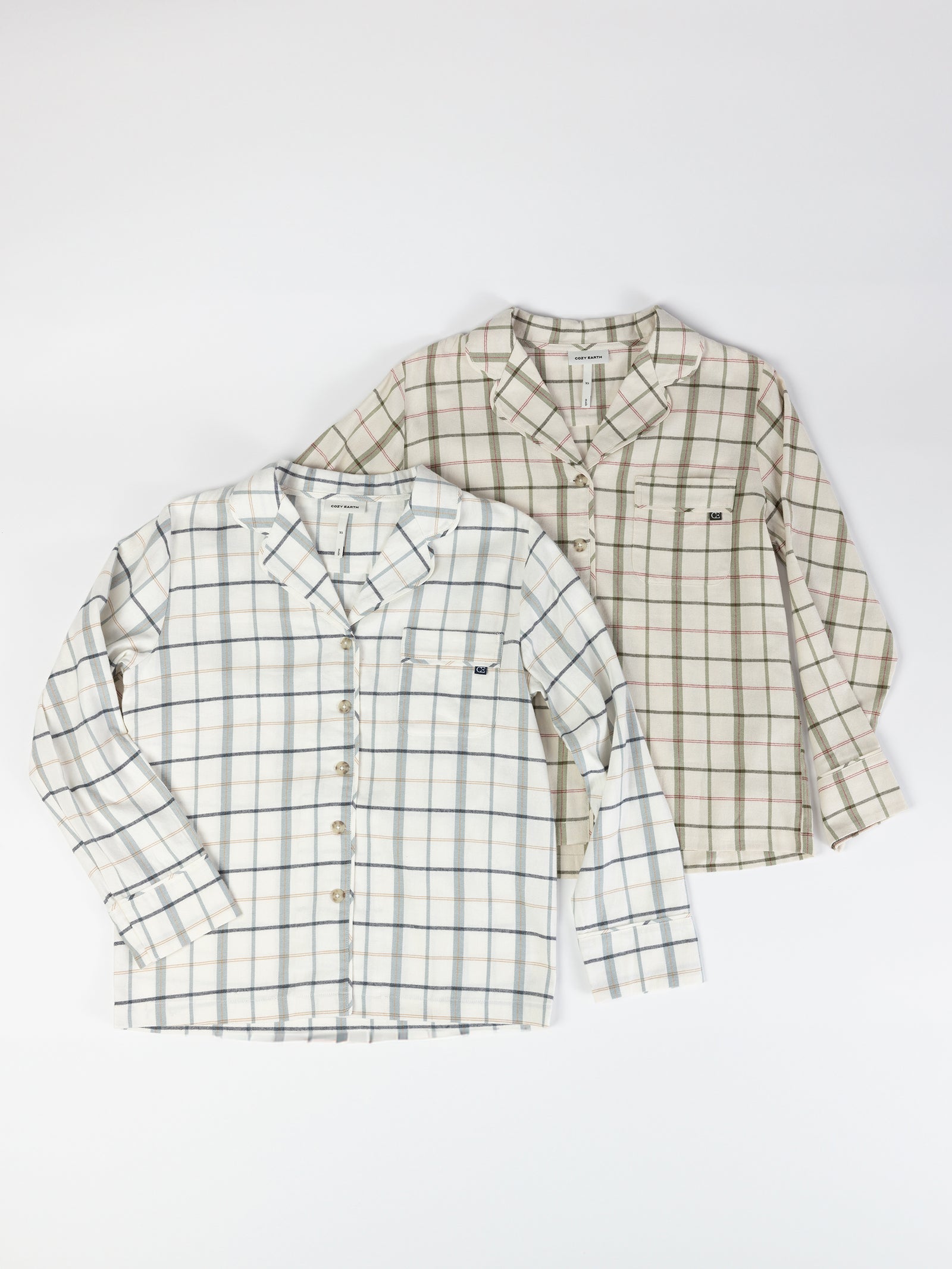 Two long-sleeve shirts from the Women's Farmhouse Long Sleeve Pajama Set by Cozy Earth are displayed on a flat surface. Both shirts have a plaid pattern, one with a white base and blue and gray stripes, the other with a beige base and brown and green stripes. Each shirt features a chest pocket. 