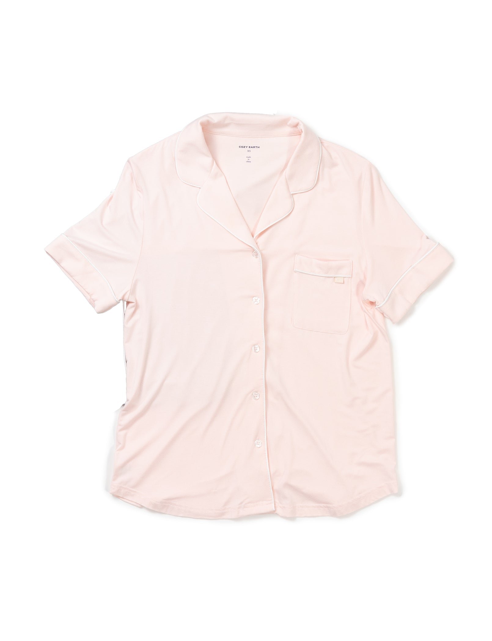 The Cozy Earth Women's Bamboo Stretch-Knit Pajama Set includes a light pink short-sleeve button-up top with a collar, white piping, and a front left pocket.
