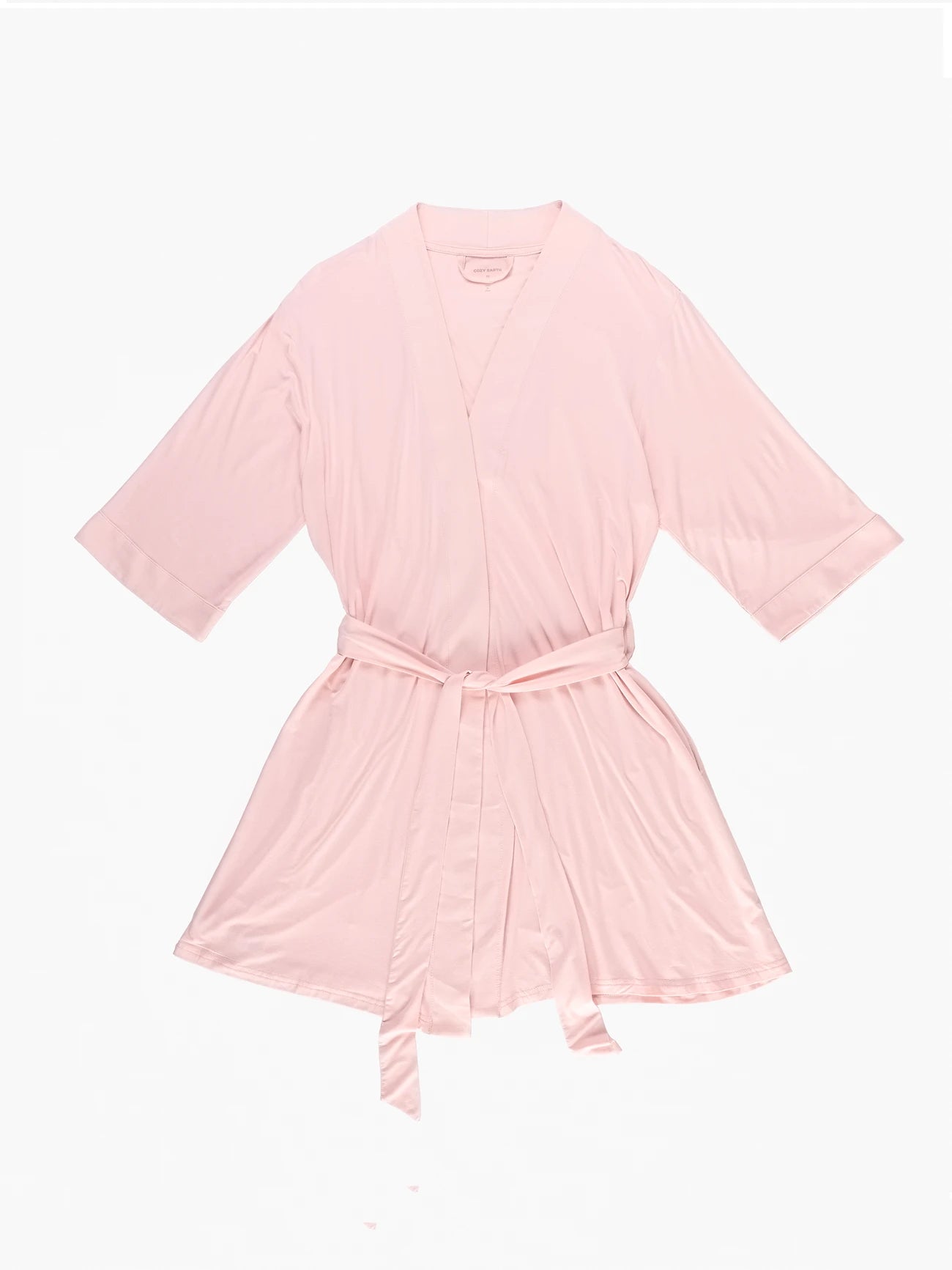 The Women's Stretch-Knit Bamboo Kimono Robe by Cozy Earth is displayed flat on a white background. It is light pink, knee-length, with three-quarter sleeves and comes with a matching fabric belt for closure, offering a simple and elegant design. 