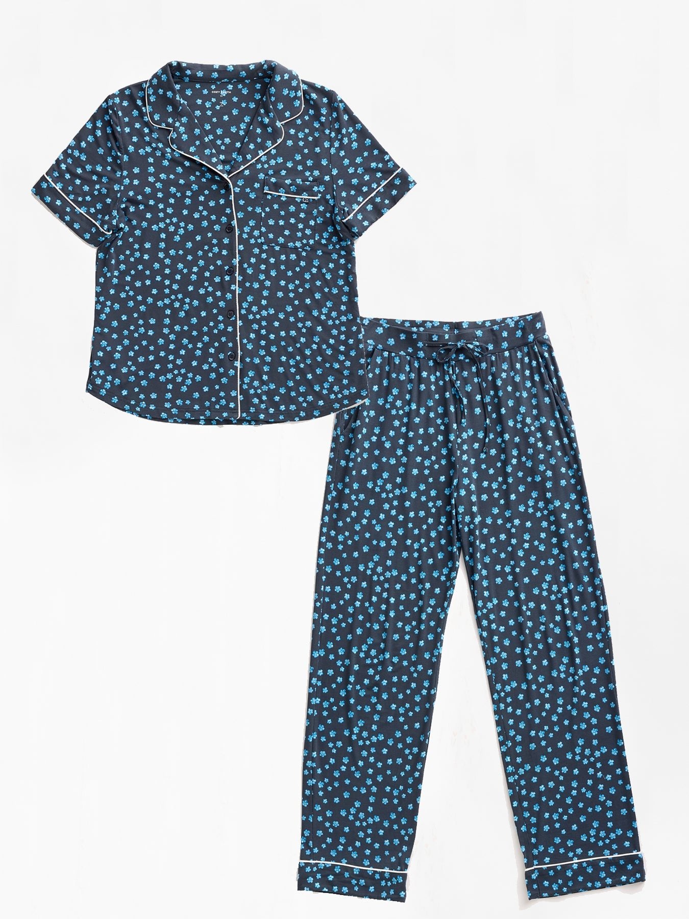 Cozy Earth's Women's Bamboo Stretch-Knit Short Sleeve & Pant Pajama Set is a two-piece set with a collared, short-sleeved shirt and matching pants in dark blue with light blue polka dots, detailed with white piping. 