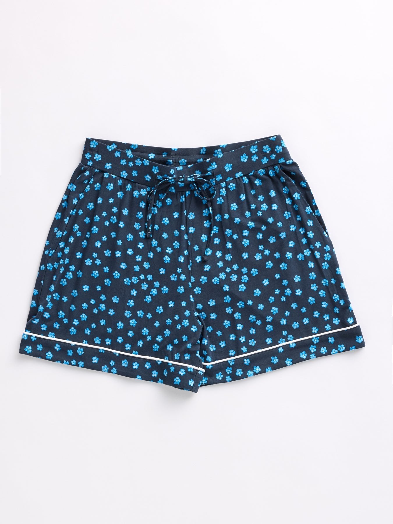 From the Women's Bamboo Stretch-Knit Short Sleeve Pajama Set by Cozy Earth, these shorts are dark blue with a small blue flower pattern, white-trimmed hems, and an adjustable drawstring waist. They appear lightweight and are displayed flat on a white background. 