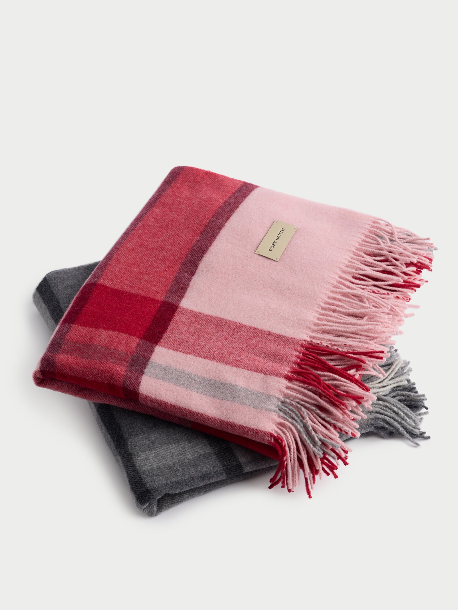 Pink and grey lucca throws folded with white background 