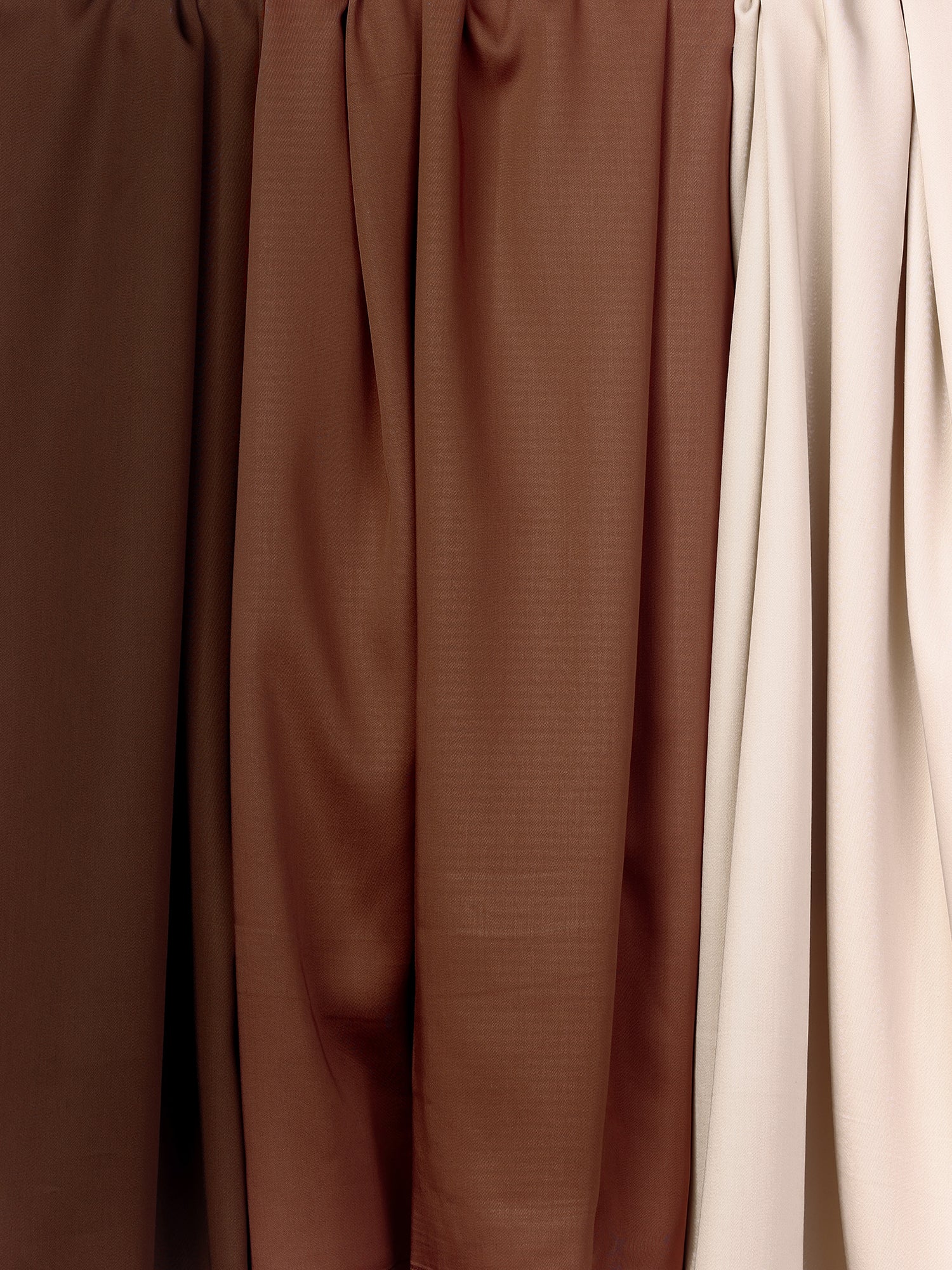 Four Bamboo Duvet Covers by Cozy Earth in varying shades of brown and beige are arranged side by side. The colors transition smoothly from a dark, rich brown on the left to a light beige on the right. The material appears soft and subtly textured. 