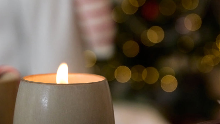 Candle in a ceramic holder with a blurred bokeh background