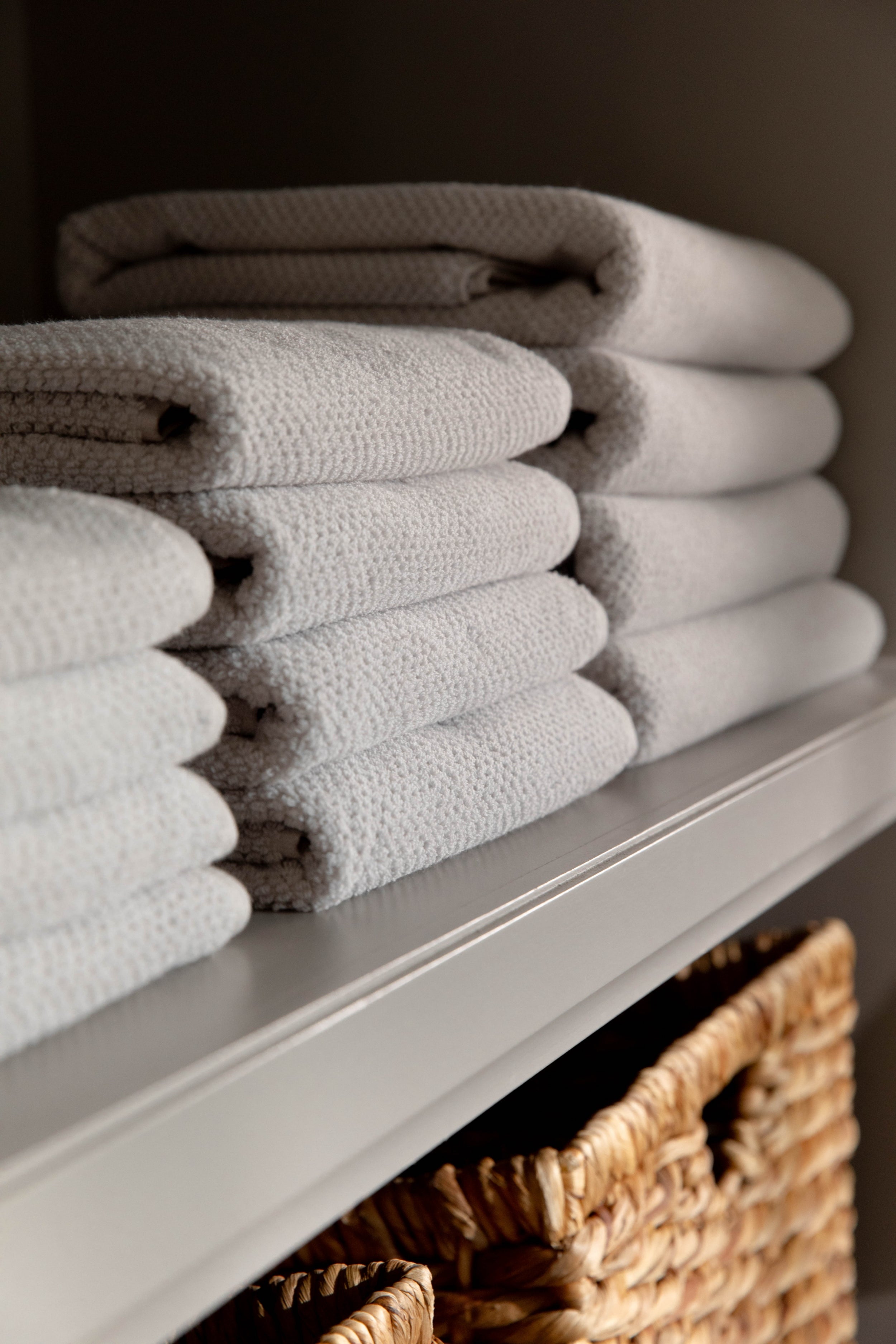 Complete Nantucket Bath Bundle in the color Heathered Light Grey. Photo of Complete Nantucket Bath Bundle taken as the towels rest on a shelf in a bathroom. |Color: Heathered Light Grey