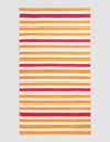 The Cozy Earth Classic Stripe Resort Towel in Mandarin Stripe features a rectangular design with horizontal orange, red, and white stripes of varying thickness on a neutral background and includes a small white corner tag.|Color:Mandarin Stripe