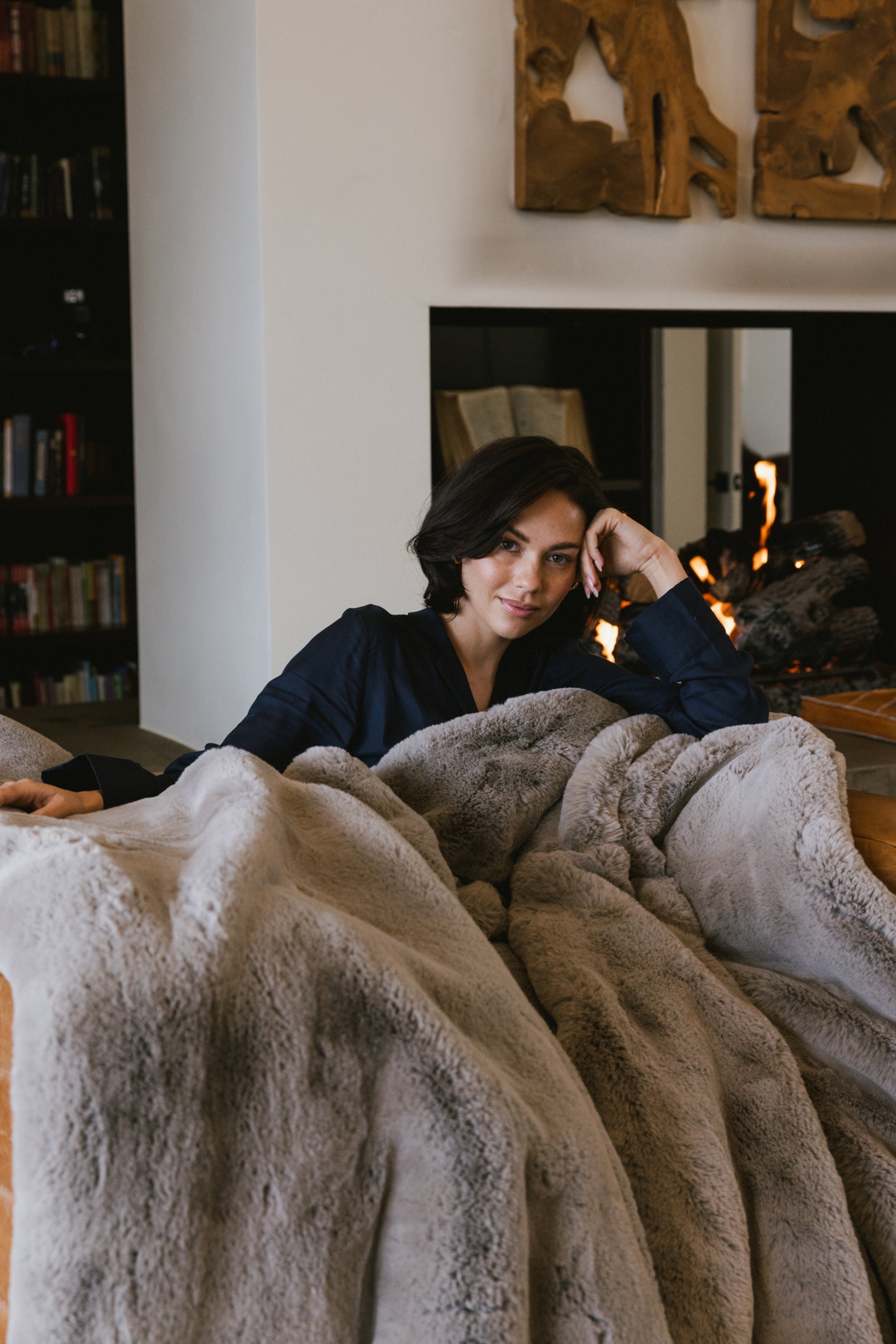 Woman sitting by the fire with Dove Grey Oversized Throw Cuddle Blanket 