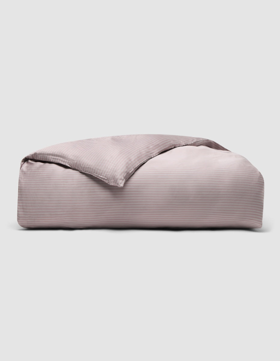 A folded light pink Cozy Earth Bamboo Duvet Cover with subtle thin horizontal stripes.